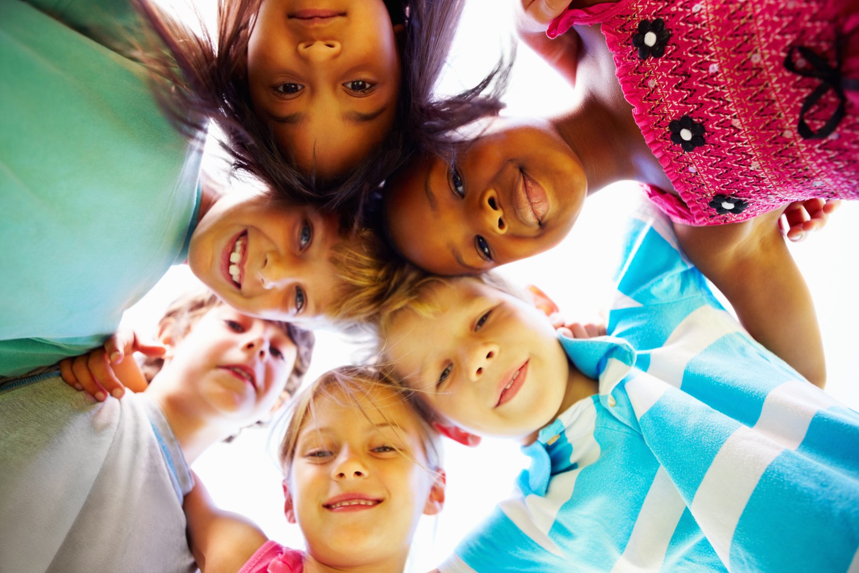 Multiracial kids huddling together